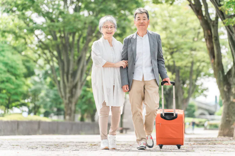 スーツケースを持つシニア夫婦